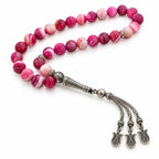 Pink Agate tasbih with banded rose beads, silver-tone imame and three tulip-shaped tassel charms on white.