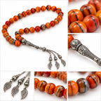 Detail collage showing striped orange Agate beads, ornate silver-tone imame and three feather-like wing charms.