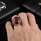 Silver ring with a red stone on a white background