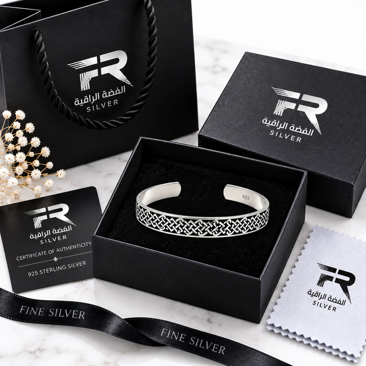 Sterling silver cuff bracelet with an intricate geometric pattern, presented in an open black gift box with its packaging, including a black shopping bag, certificate of authenticity, and microfiber cloth, all branded with 'FR SILVER'.