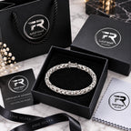 Men's 925 silver chevron Byzantine bracelet in Fine Silver branded black gift box with certificate, polishing cloth and branded bag on marble surface