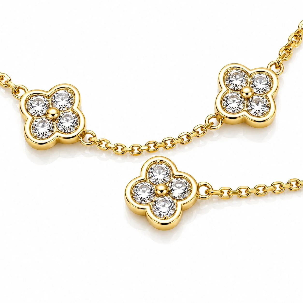 Gold necklace with clover-shaped pendants on a white background