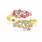 Gold ring with pink and white gemstones on a white background