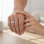 Silver ring on a person's finger against a neutral background