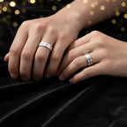 Silver ring on a person's finger against a neutral background