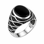 Silver ring with black gemstone on a white background