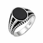 Silver ring with a black stone on a white background