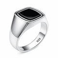 Silver ring with a black stone on a white background