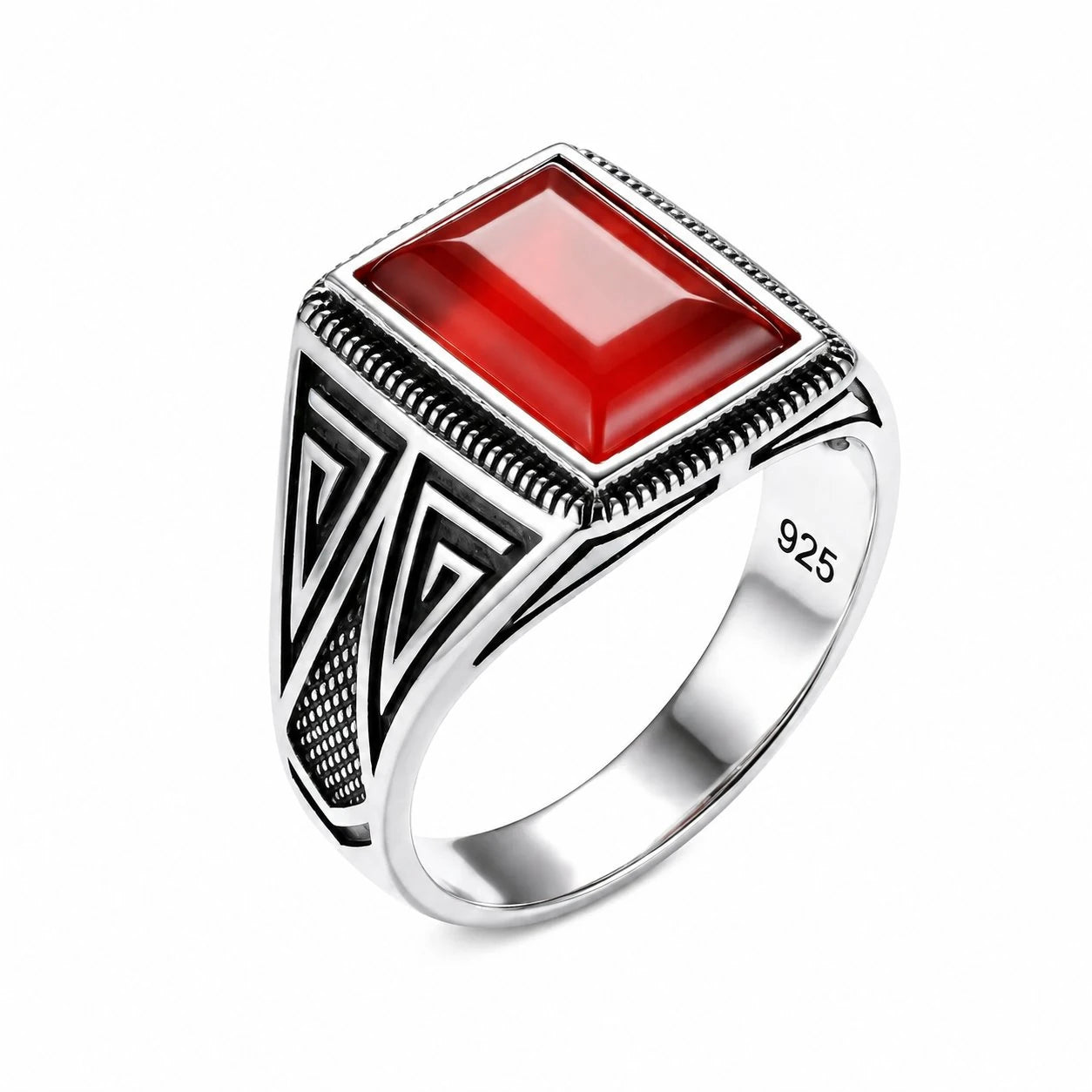 Silver ring with a red stone on a white background