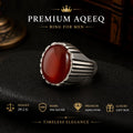 Silver ring with a red stone on a dark background, featuring Premium Aqeeq branding.