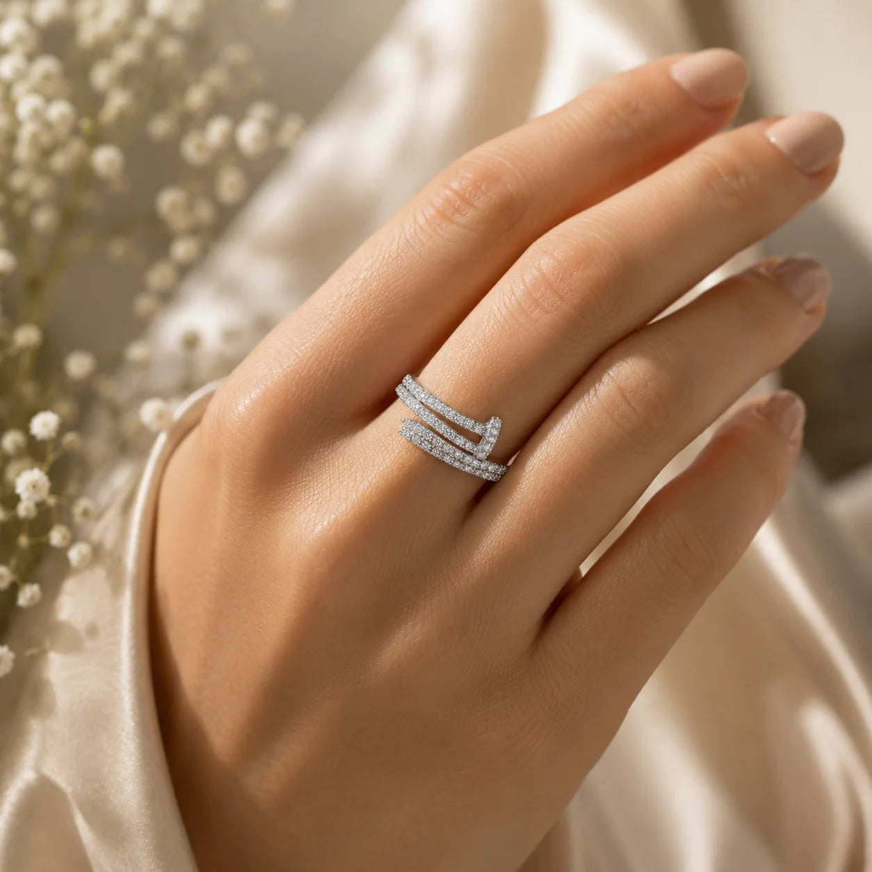 Hand wearing a silver ring with a soft background