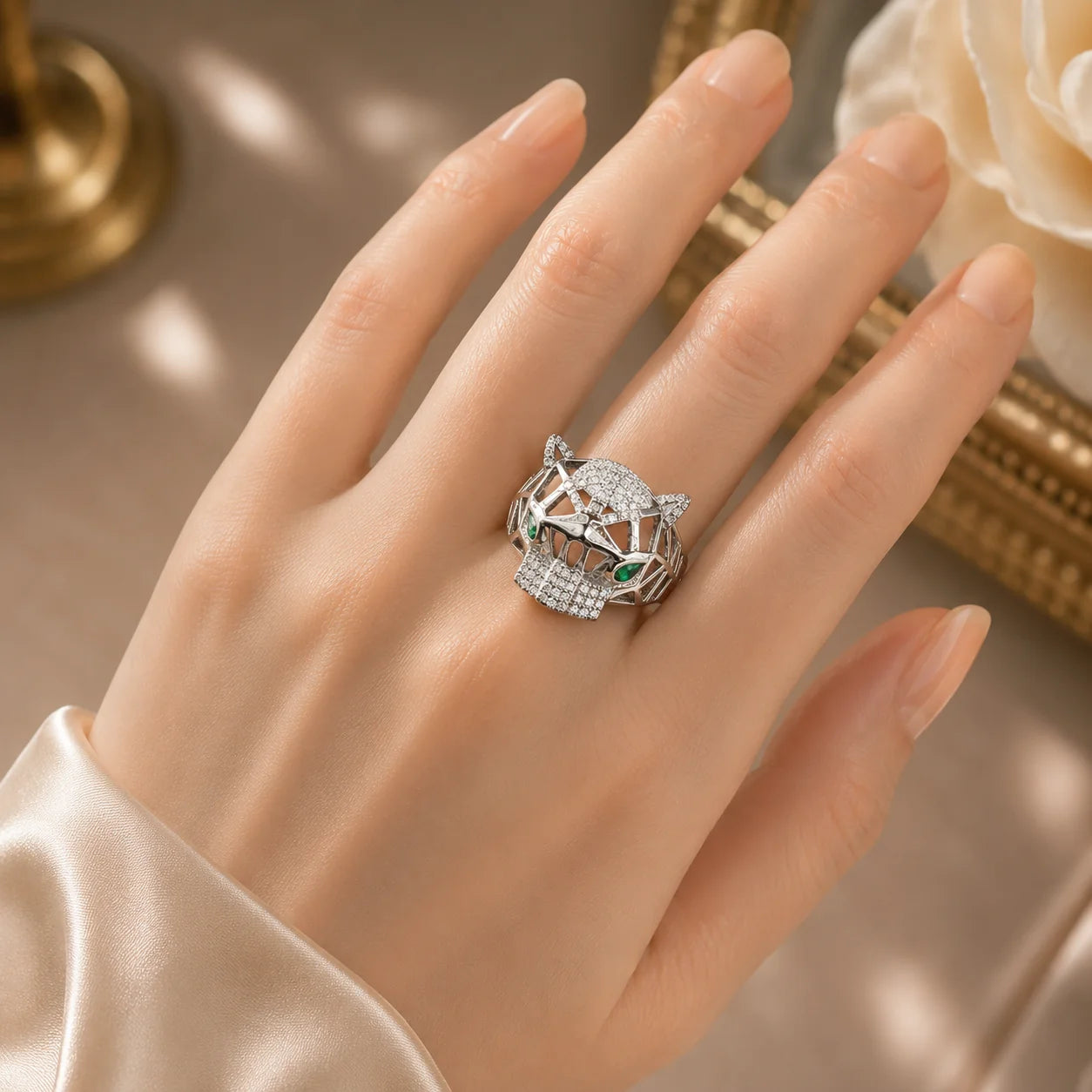 Hand wearing a decorative ring with gemstones on a neutral background