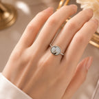 Hand wearing a ring with a swan design on a neutral background