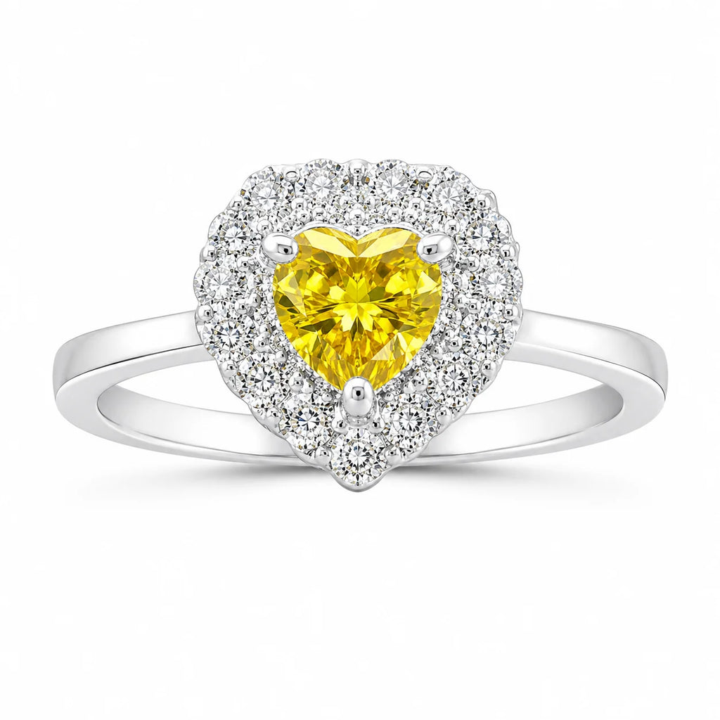 Heart-shaped ring with a yellow gemstone and diamond accents on a white background