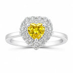 Heart-shaped ring with a yellow gemstone and diamond accents on a white background