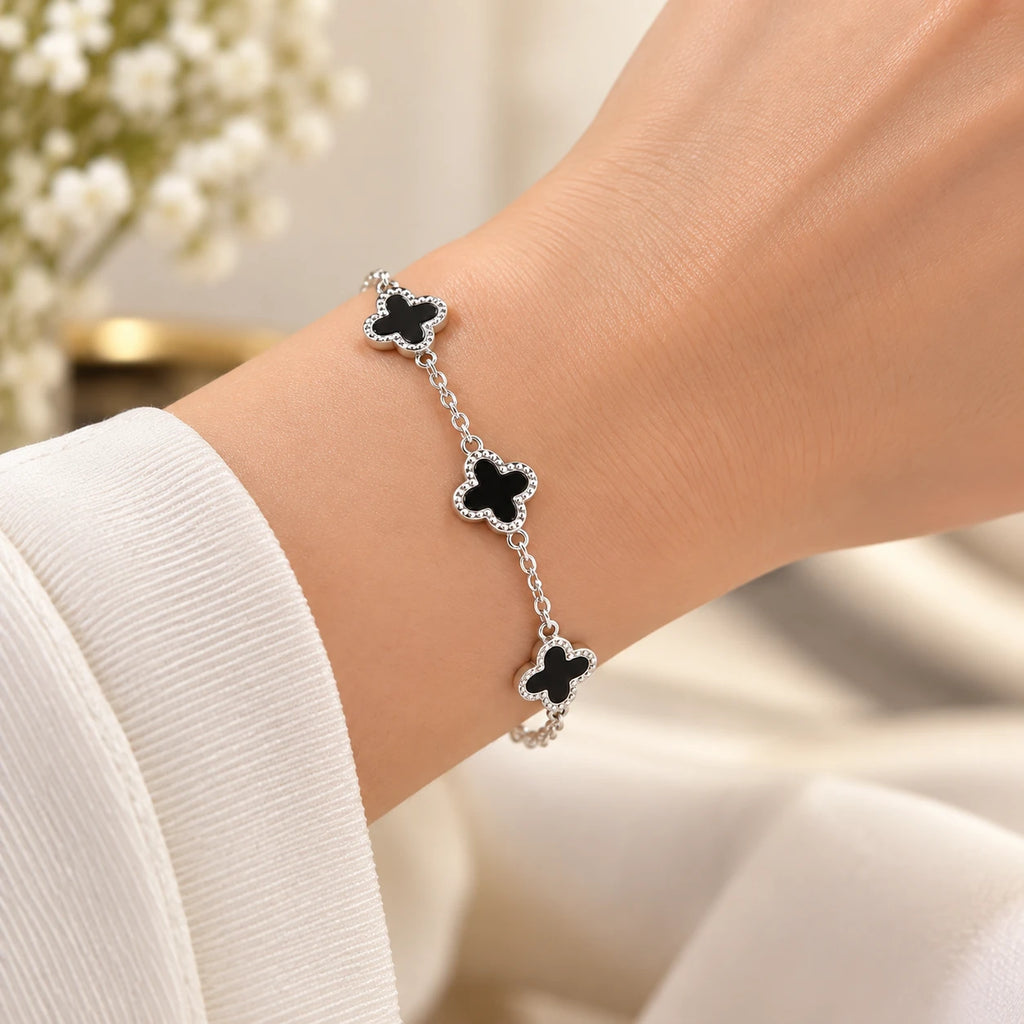 Women's 925 silver black onyx clover bracelet worn on wrist with white sleeve, lifestyle shot, Fine Silver KSA