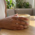 Women's 925 silver blue sapphire CZ pearl open ring worn on finger, lifestyle shot at café, finesilverofficial.com