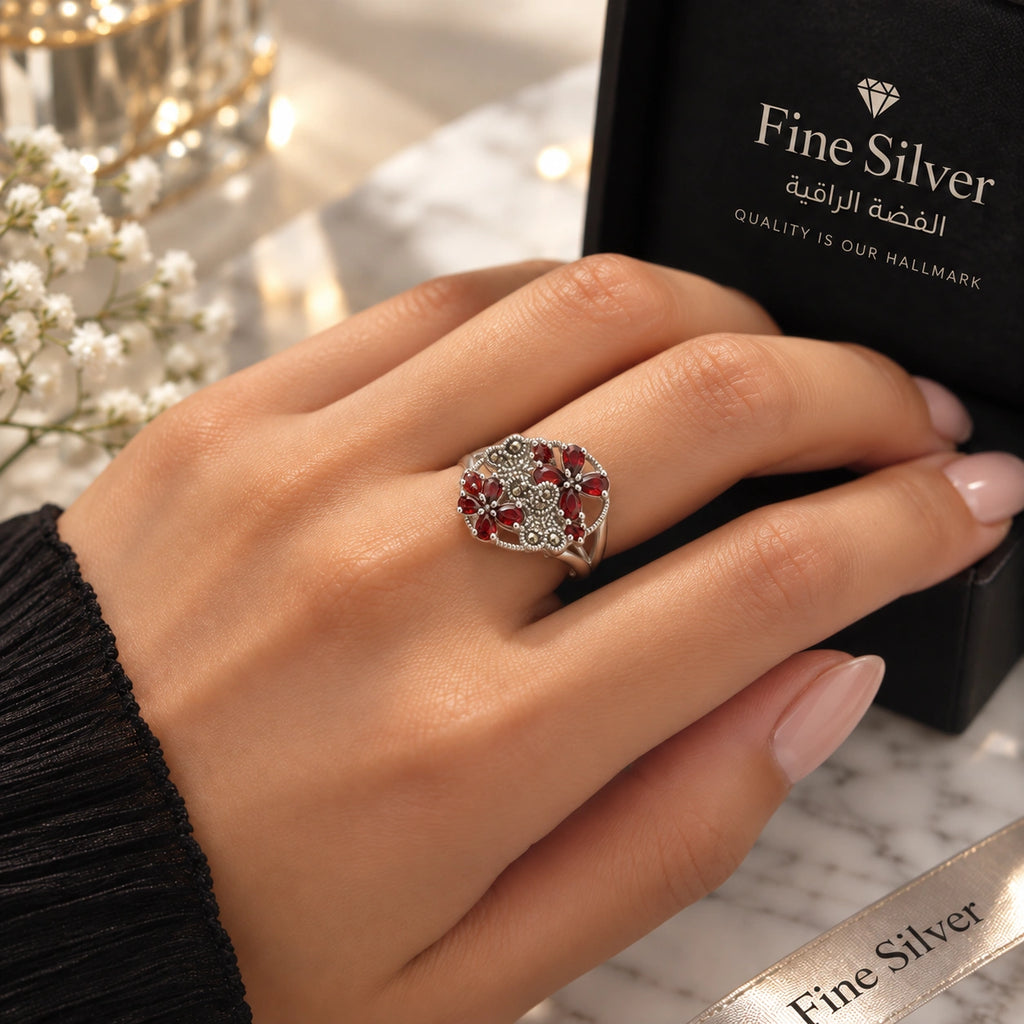 Women's 925 silver red CZ floral marcasite ring worn on woman's finger beside Fine Silver gift box, lifestyle shot, KSA